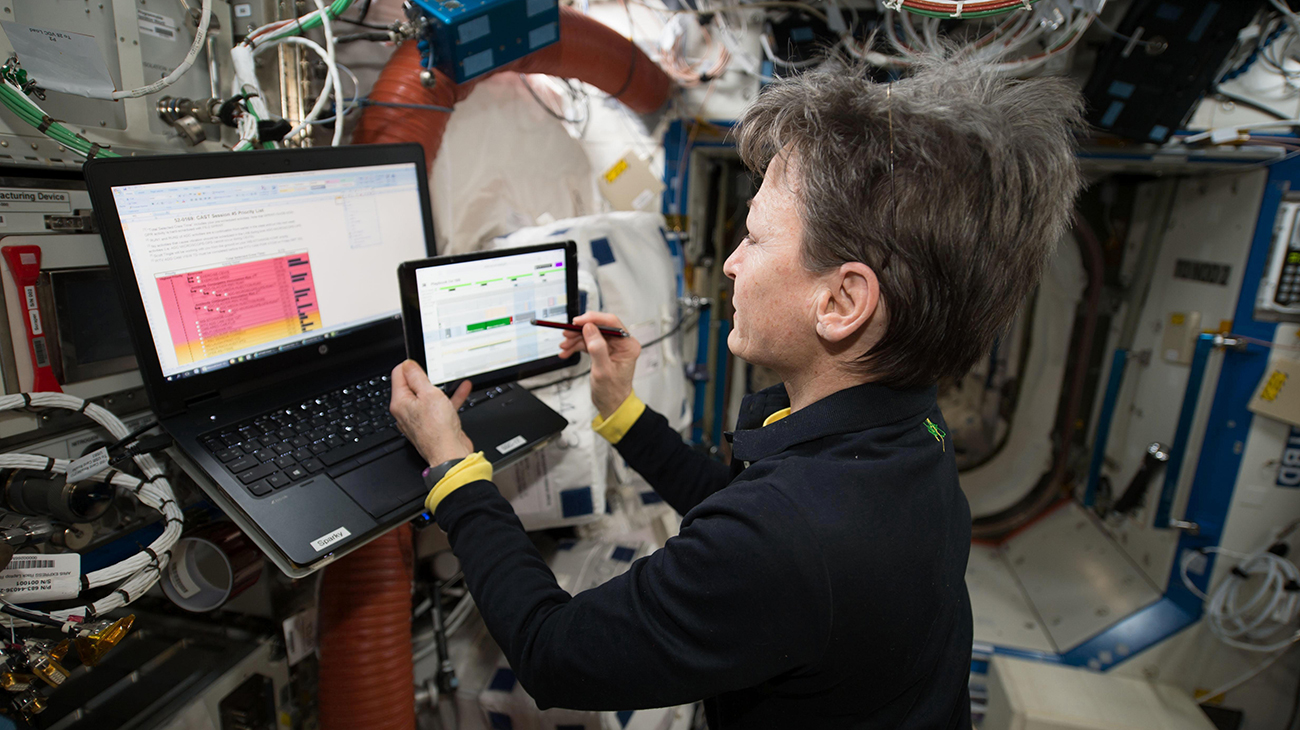 NASA astronaut Peggy Whitson operates the Playbook mission planning software on a tablet computer aboard the International Space Station, demonstrating crew-driven timeline management capabilities for future autonomous operations.